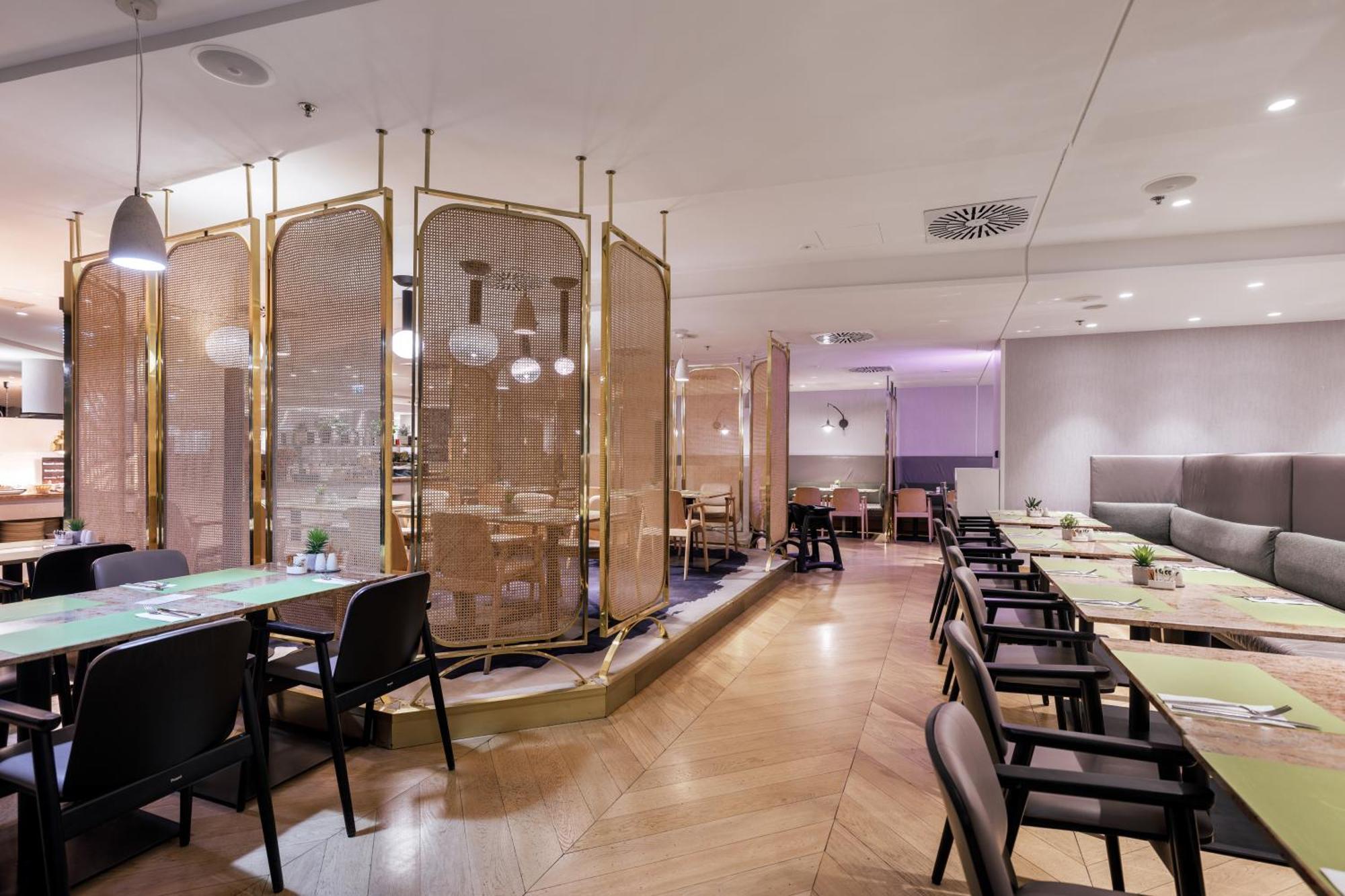 Radisson Blu Resort Swinoujscie Kültér fotó The photo depicts a modern restaurant interior. It features a layout with several tables and chairs arranged in an organized manner. There is a decorative partition made of delicate mesh or fabric, providing some privacy between different dining area