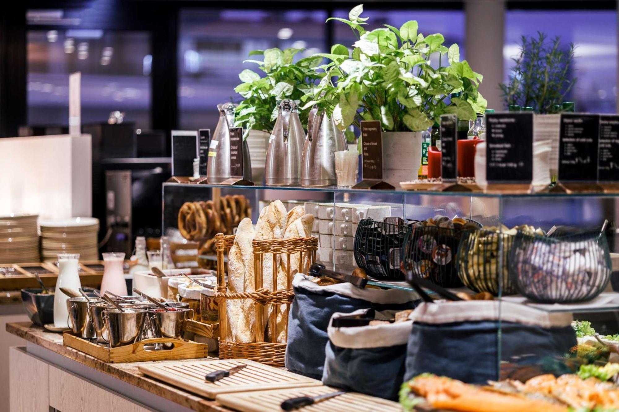 Radisson Blu Resort Swinoujscie Kültér fotó The photo depicts a beautifully arranged buffet or food display area. It features various items such as:

- Several glass or metal containers, possibly holding beverages or condiments.
- Fresh greenery in pots, suggesting a focus on natural elements.