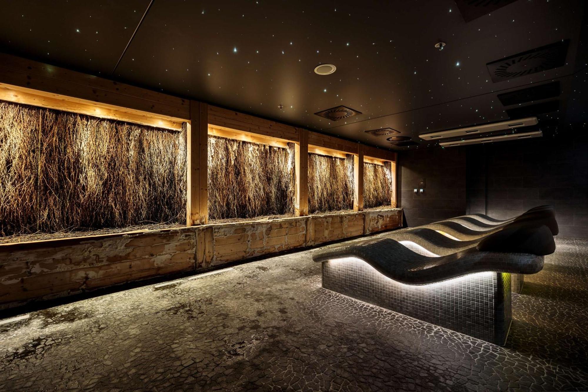 Radisson Blu Resort Swinoujscie Kültér fotó The photo depicts a modern, serene spa or relaxation space. It features several wooden-framed windows that showcase natural elements, possibly dried grass or plants, creating a calming atmosphere. The walls are dark, and the ceiling may have lights r